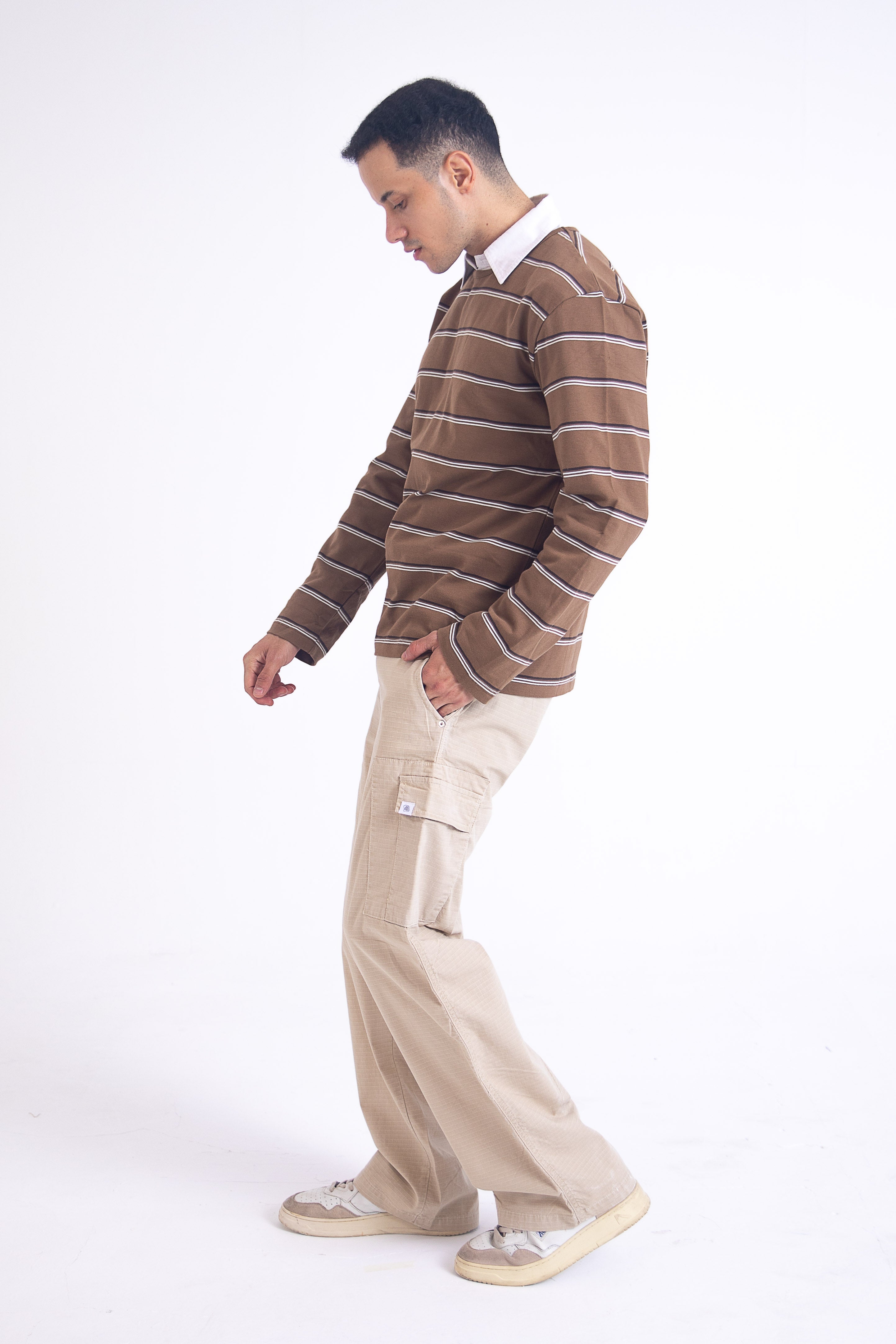 Man wearing a brown striped sweater and beige cargos 